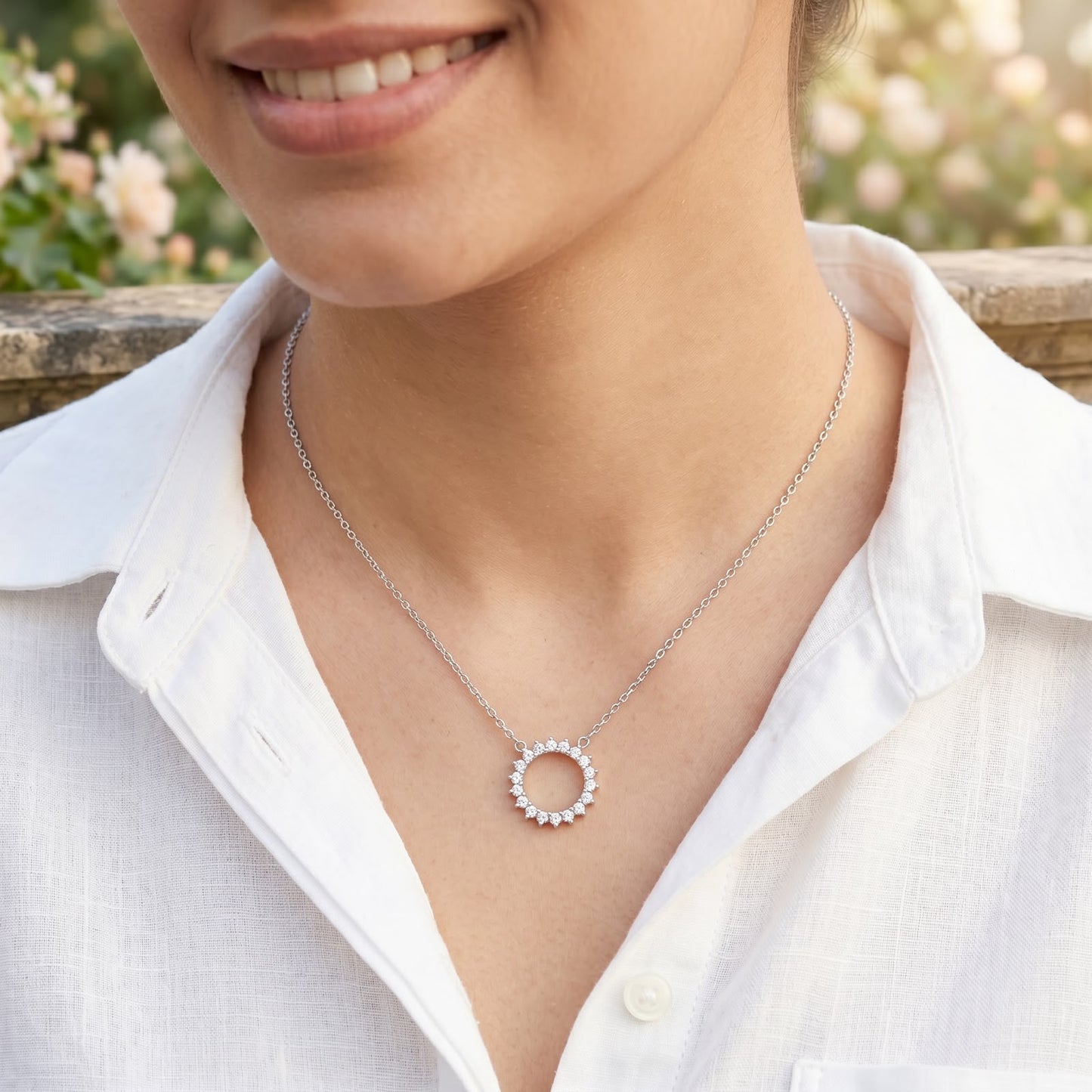 Front view of a 925 silver chain necklace featuring a sparkling stone-studded circular halo pendant, worn on a woman's neckline.