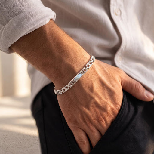 Side angle of a man's wrist wearing a 925 sterling silver bracelet featuring an oval center inlay and geometric links.