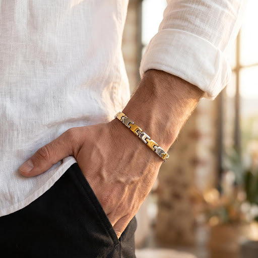 Side angle of a man's wrist wearing a 65% purity silver bracelet with dual-tone silver and gold interlocking links.
