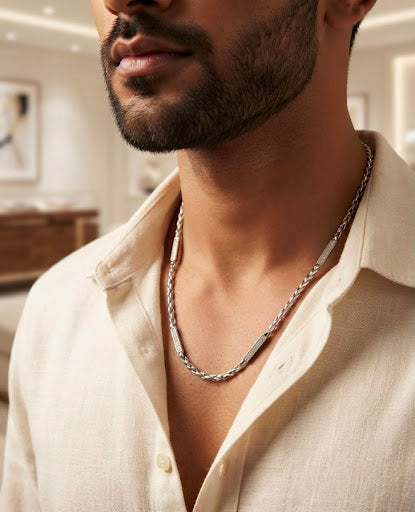 Close-up of a man wearing a 20-inch 925 sterling silver twisted rope chain with pave stone bars over an open cream shirt.