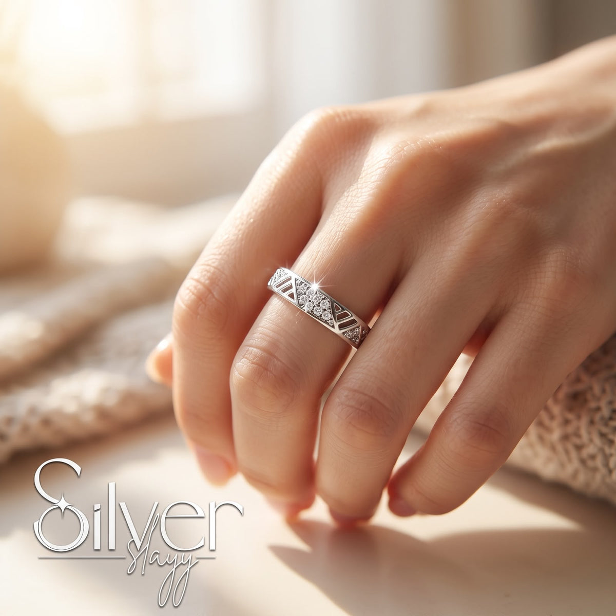 925 sterling silver geometric triangle pattern ring with centre stone worn on a woman's finger in natural daylight.