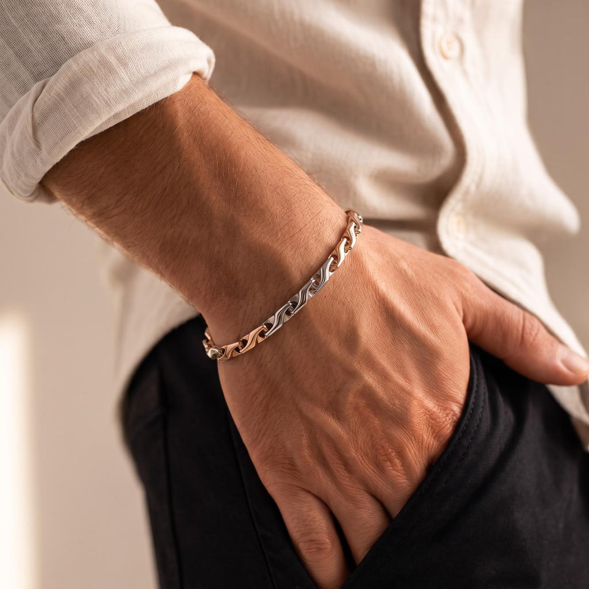 925 silver men's bracelet with curved interlocking links and mixed-tone detailing, worn around the wrist with a light shirt.