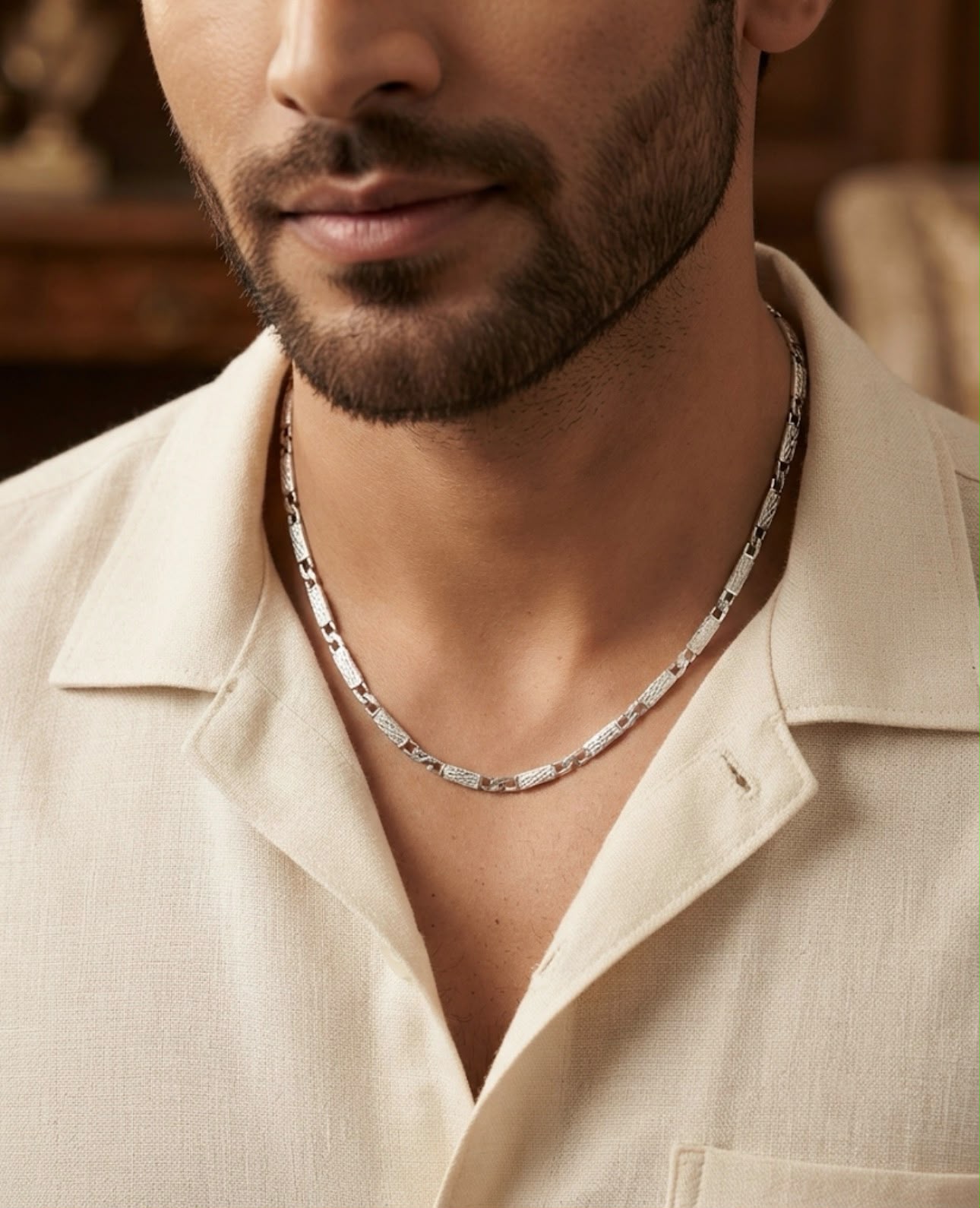 Man wearing a 925 sterling silver chain with textured rectangular links around the neckline.