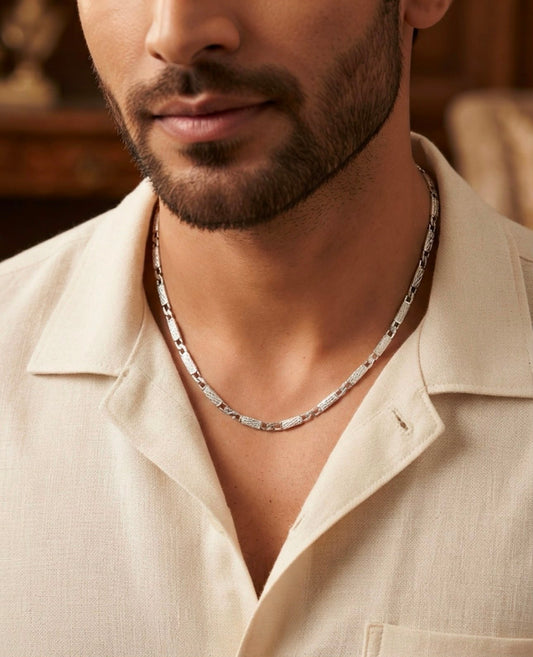 Man wearing a 925 sterling silver chain with textured rectangular links around the neckline.