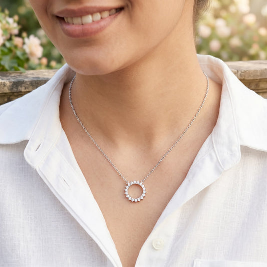 Front view of a 925 silver chain necklace featuring a sparkling stone-studded circular halo pendant, worn on a woman's neckline.