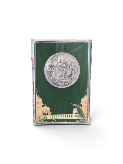 silver gifting coin featuring a detailed devotional relief design in a decorative green presentation package.