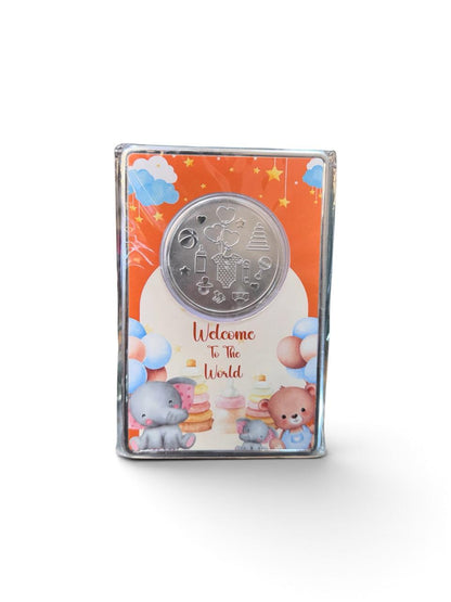 999 silver gifting coin with baby-themed relief motifs and colourful Welcome To The World presentation packaging.