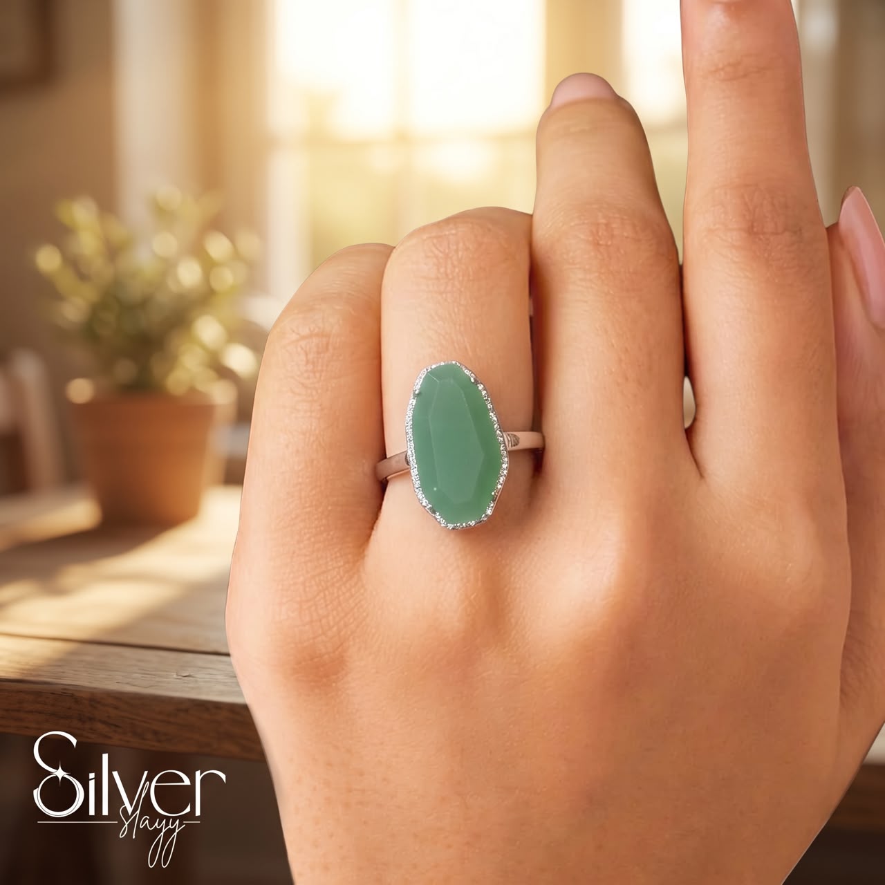 925 sterling silver ring with a green oval stone worn on a woman's finger in natural light.