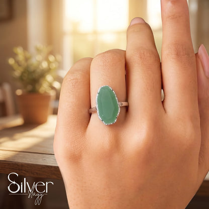 925 sterling silver ring with a green oval stone worn on a woman's finger in natural light.