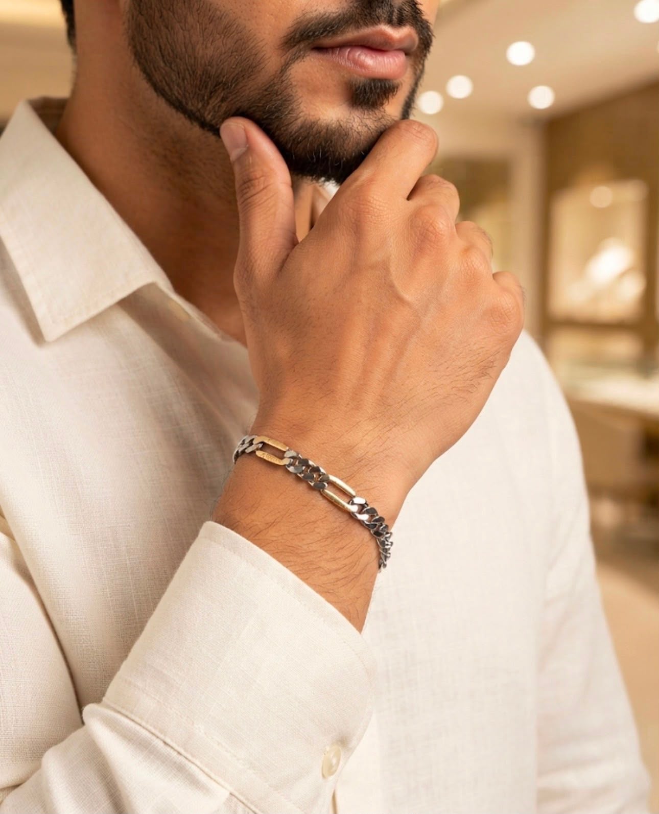 Close-up of a 925 sterling silver bracelet with dual link bar chain design worn on a man's wrist with a white shirt.