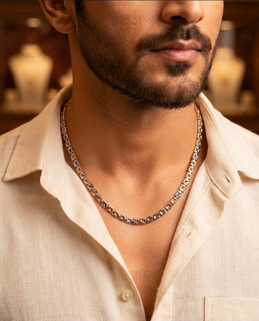 Close-up of a 925 sterling silver chain with faceted diamond-cut links worn around a man's neck with an open-collar shirt.
