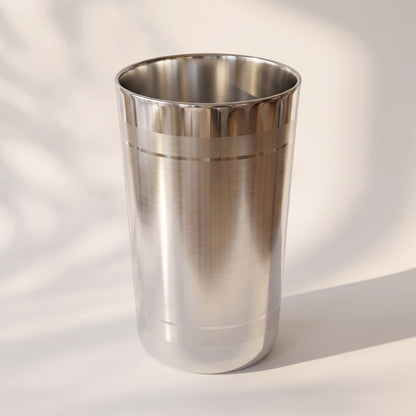 Angled view of a 925 sterling silver tumbler with brushed body and polished ring grooves on a light surface