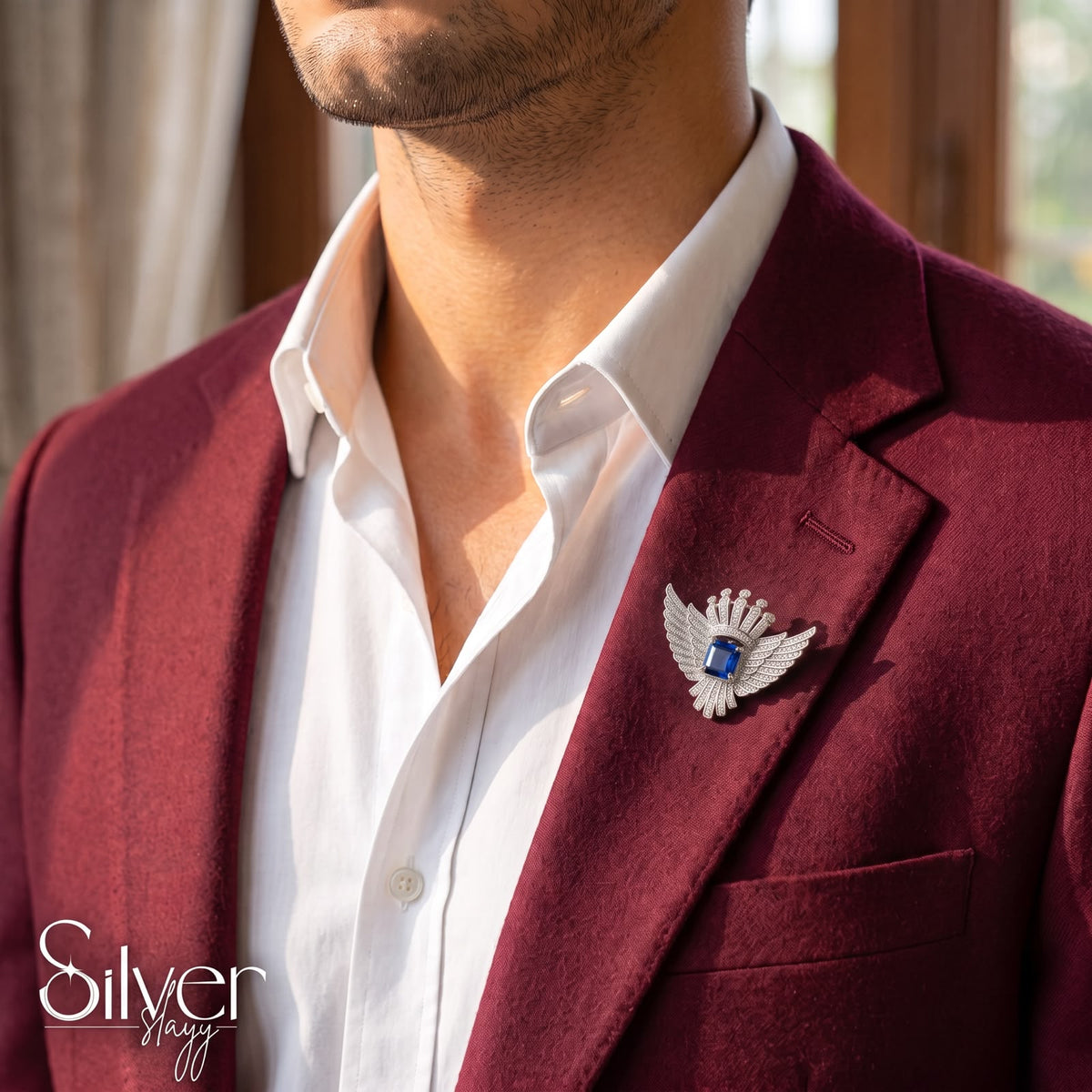 925 sterling silver royal blue stone winged brooch pinned to a maroon suit blazer for men.