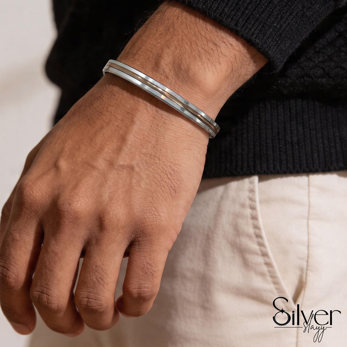 Man wearing a 925 silver bracelet with parallel polished lines and an openable cuff design