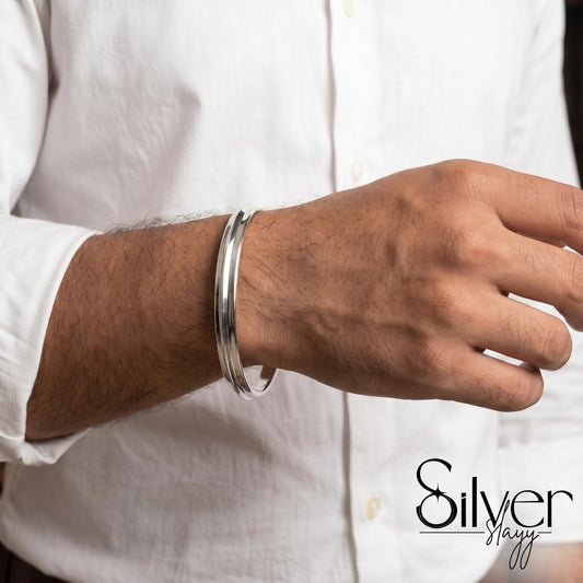 Man wearing a 925 silver bracelet with polished twin-band cuff design on his wrist.
