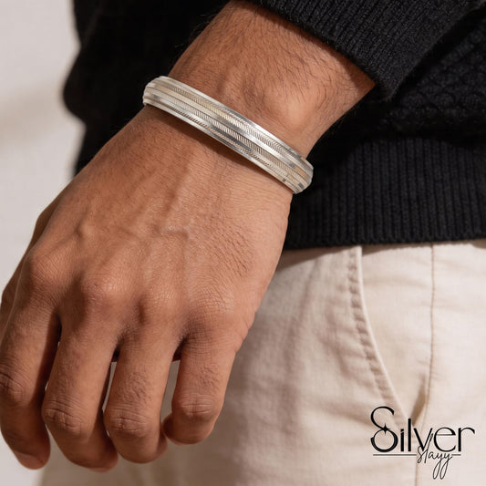 Man wearing a 925 silver bracelet with layered bands and fine herringbone edge detailing on his wrist.