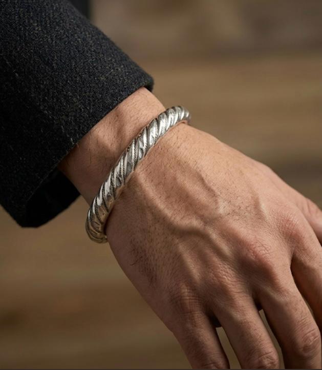 925 silver men's kada with textured twisted detailing, shown worn around the wrist.