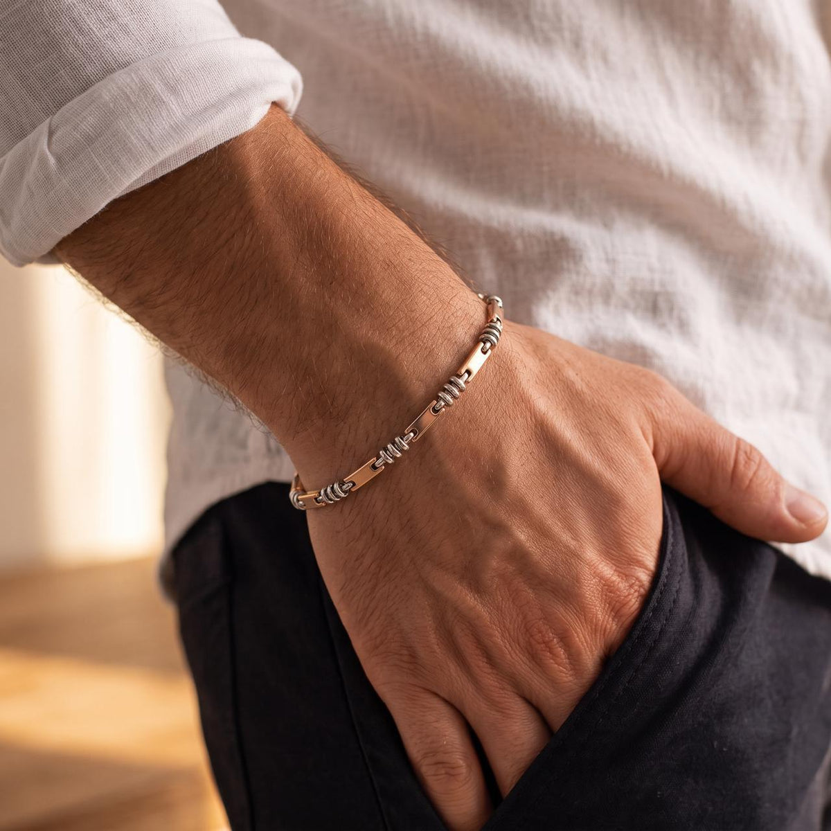 925 silver men's bracelet with rectangular bar links and coiled ring accents, worn around the wrist with a white shirt.