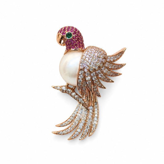 Close-up of a 925 sterling silver perched parrot brooch featuring a white pearl belly, pink stone head, and crystal-studded wings on a white background.