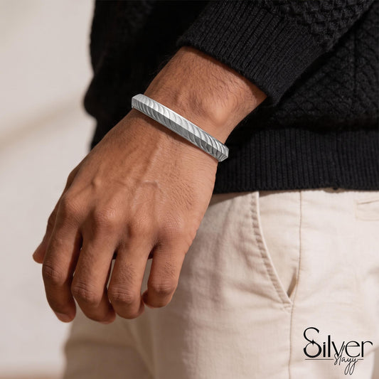 Man wearing a 925 silver bracelet with a textured wave-pattern design on his wrist.